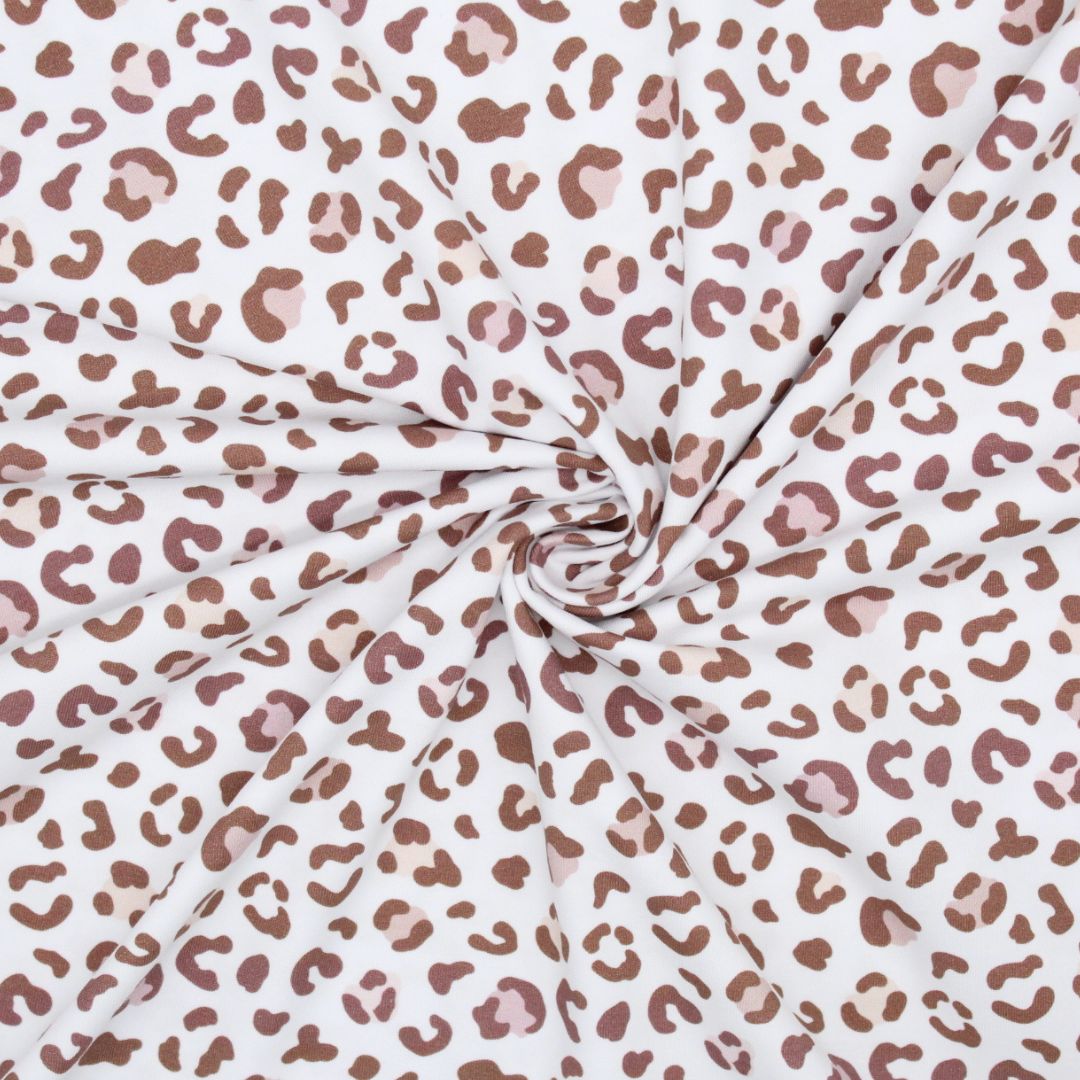 Jersey-Meterware mit lebendigem Leopardenmuster in Braun auf Weiß – vielseitig für verschiedene DIY-Ideen.