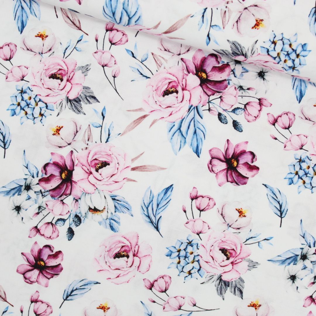 Baumwollstoff mit zarten blauen und lila Blumenmustern auf sanftem Hintergrund