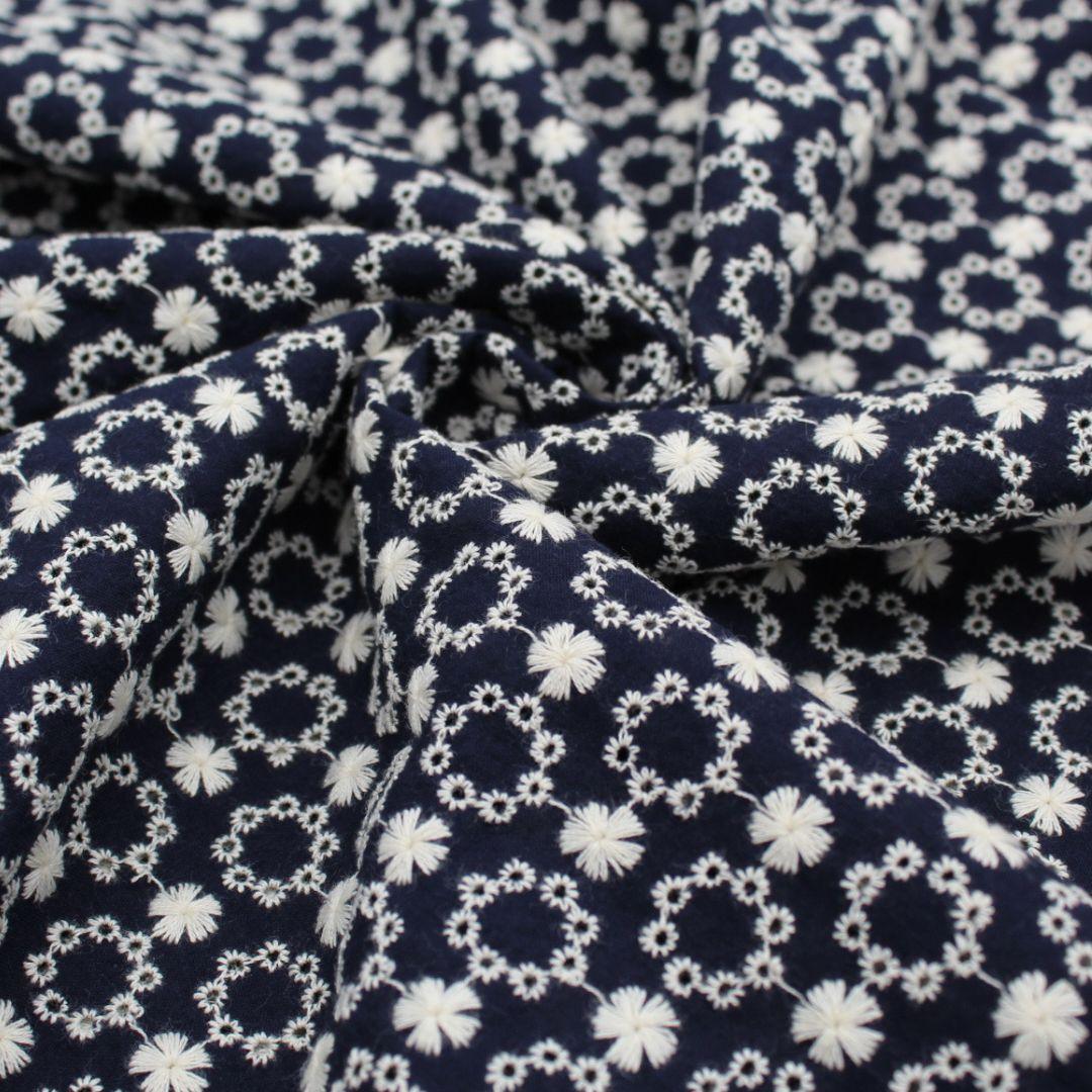 Stoffstück des marineblauen Baumwollstoffs mit Blumenstickerei