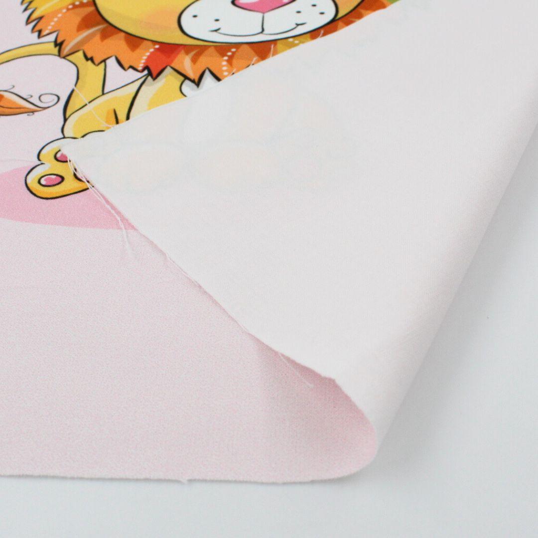 Nahaufnahme vom Baumwollpanel mit süßem Löwenmotiv auf rosa Hintergrund. Nahaufnahme auf Stoff