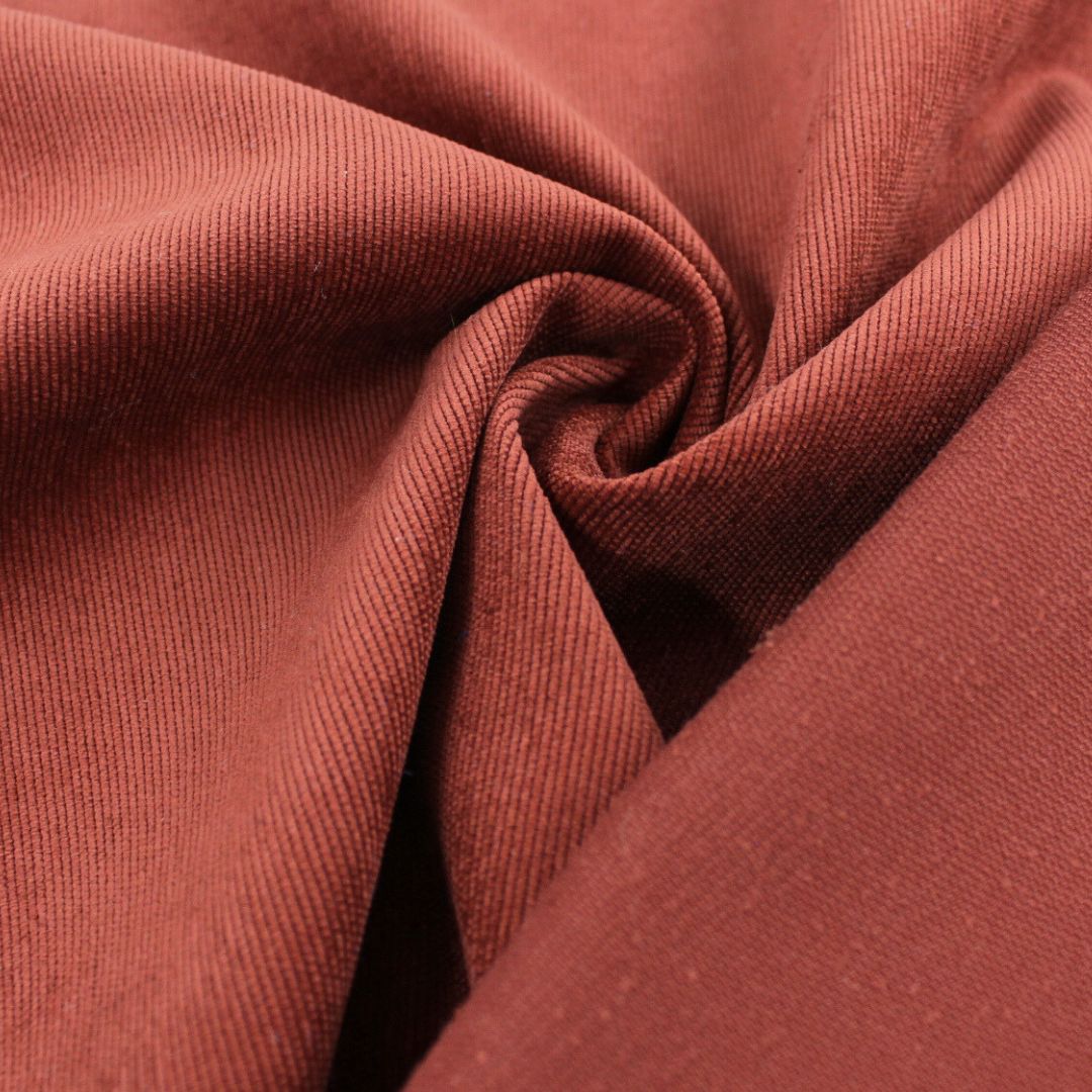 Feincord-Stoff in Rostrot mit samtiger Oberfläche, ideal für Kleidung und Accessoires.