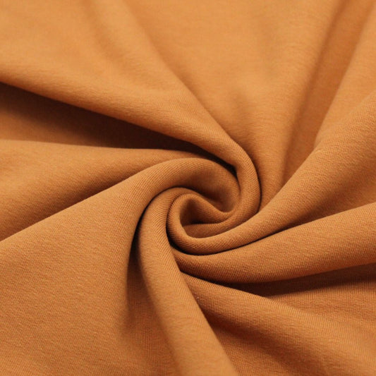 Nahaufnahme von angerautem French Terry Stoff in Karamellbraun, ideal für bequeme Sweatshirts und Hoodies.