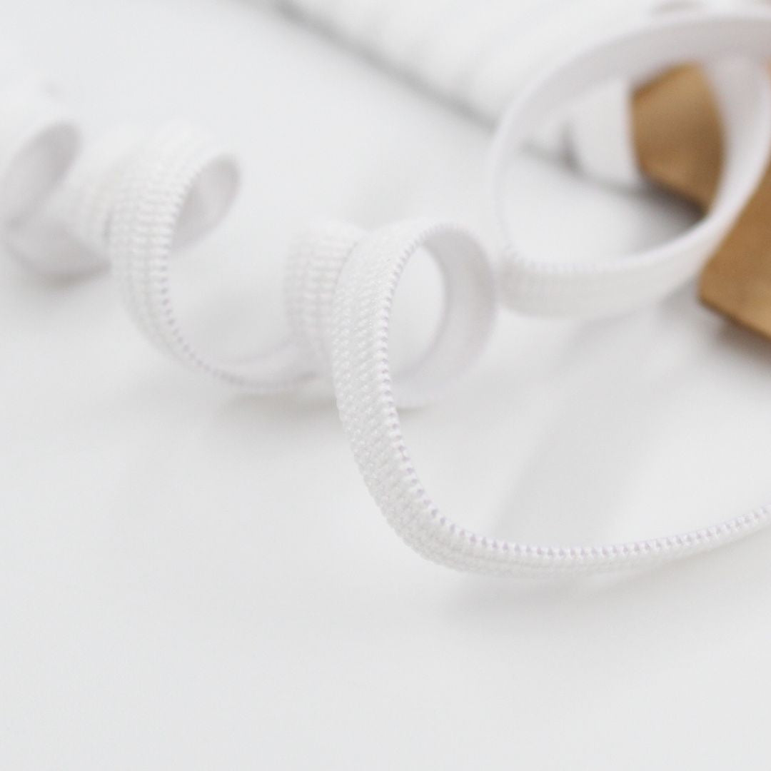 Nahaufnahme eines weißen Gummibands mit feiner Textur, 5 mm breit – hochwertiges Elastikband aus Latex und Polyester.