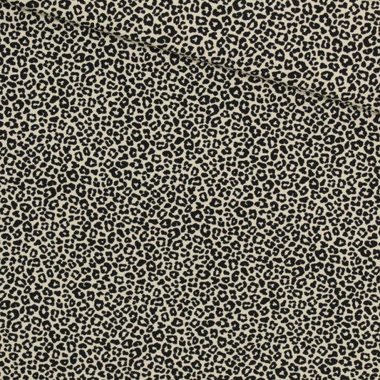 Detailansicht des Jerseys mit schwarzem Leopardenmuster auf beigem Hintergrund – weicher und elastischer Stoff für modische Nähprojekte.