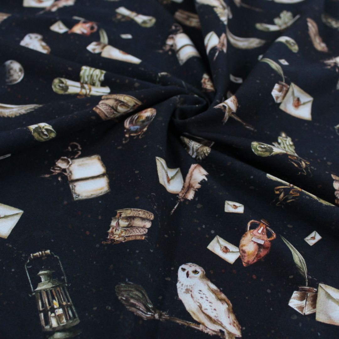 Hochwertiger Jersey Stoff Magische Schule in Schwarz mit Zauber-Motiven, perfekt kombinierbar mit uni Jerseys oder Bündchenstoffen.