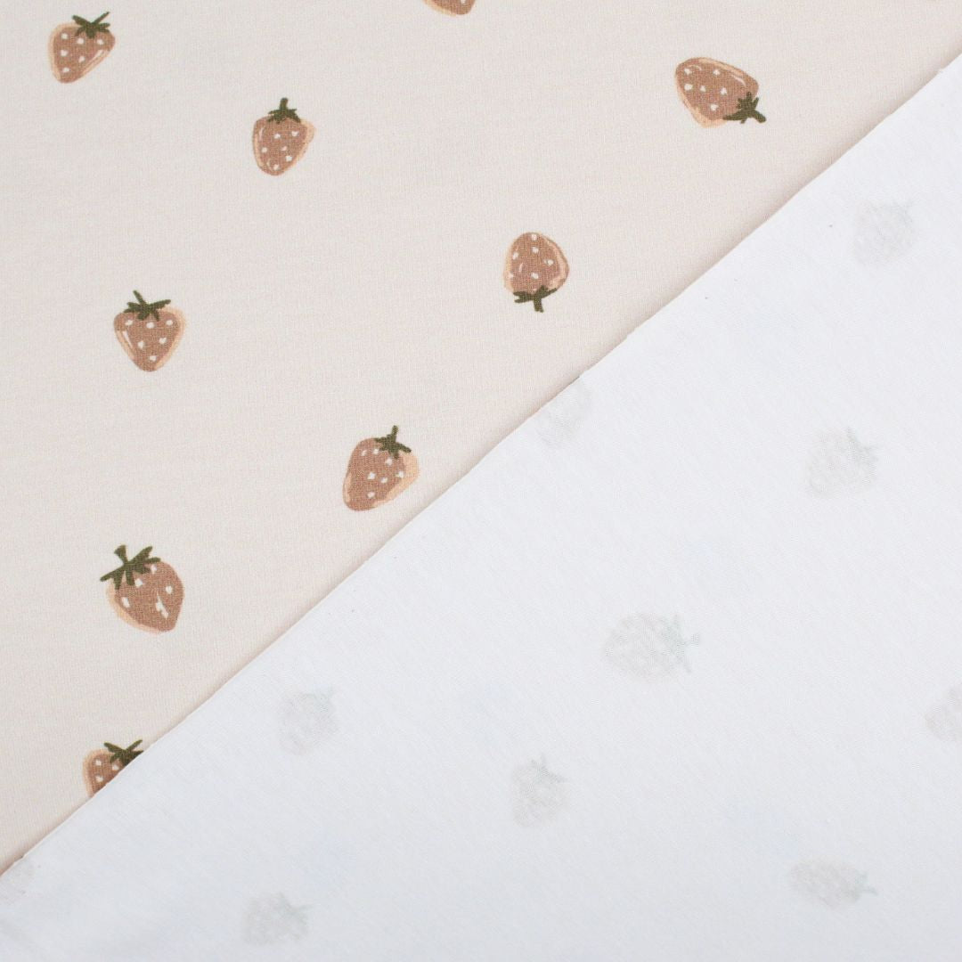 Jersey Stoff mit Erdbeeren auf Sand – glatt ausgebreitet, zeigt das Muster und die Stoffstruktur