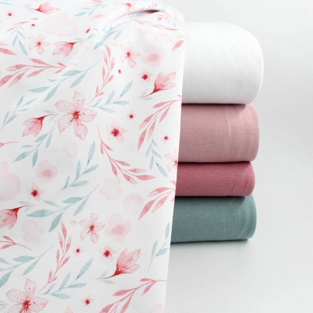 Hochwertiger Jersey mit floralen Motiven in Rosa-Blau auf Weiß – geeignet für Pumphosen, Mützen und Strampler