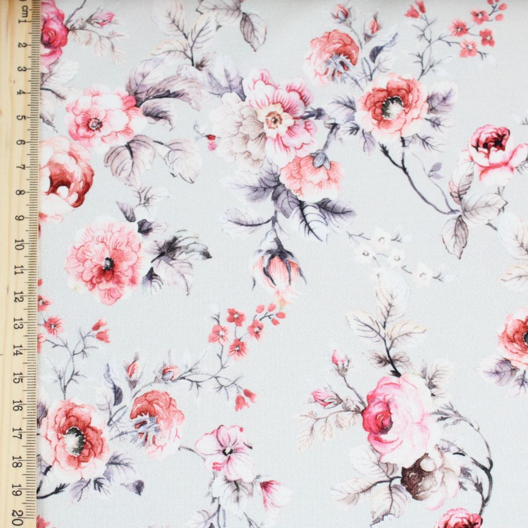 Nahaufnahme eines floralen Jerseys mit romantischem Vintage-Look in Rosa und Grau.