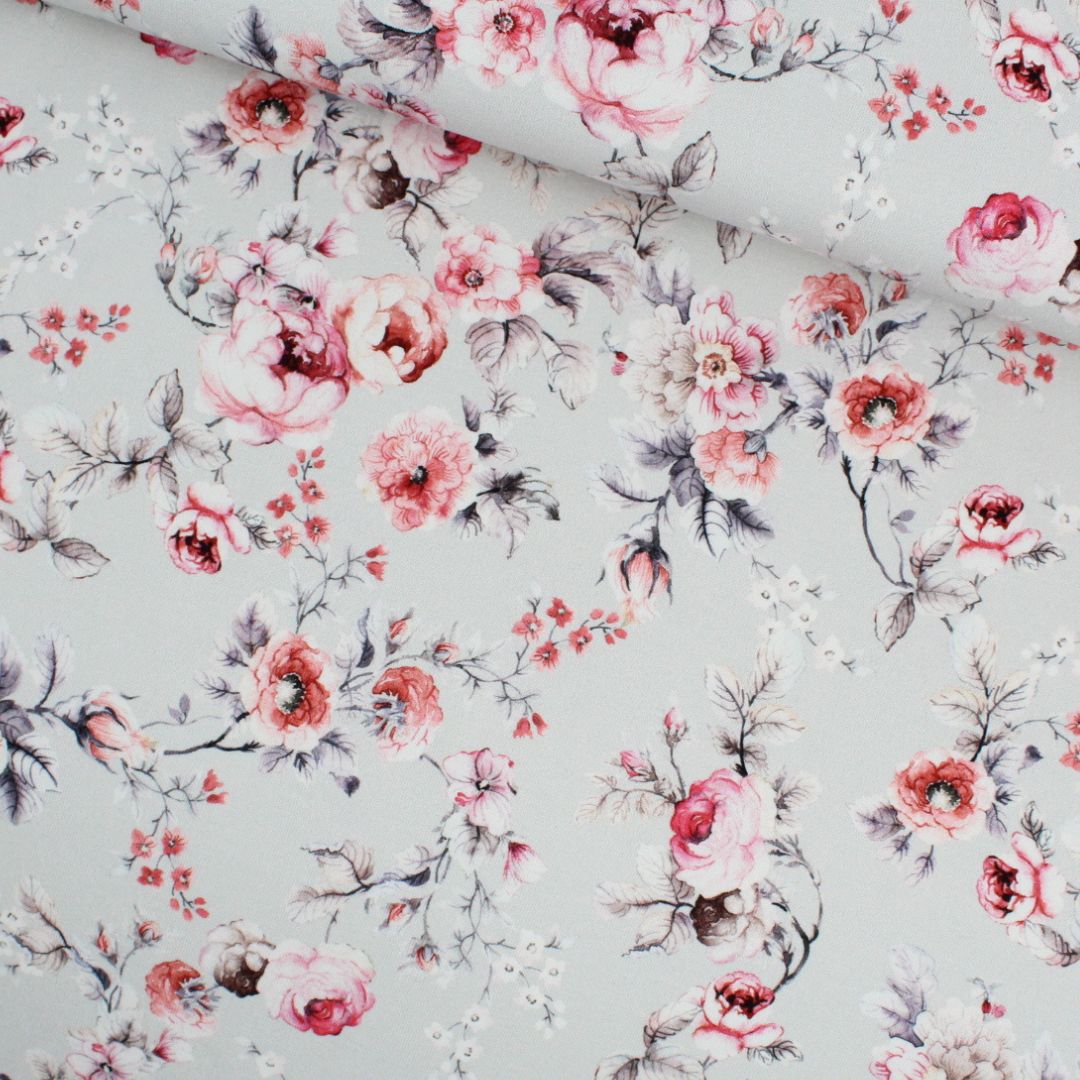 Jersey-Stoff mit rosa Blumen auf hellgrauem Hintergrund – zartes, florales Design für feminine Nähprojekte.