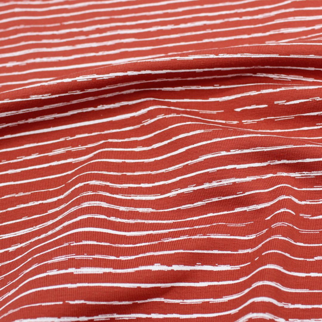 Weicher und elastischer Jersey-Stoff mit weißen unregelmäßigen Streifen, ideal für Kleidung und modische Nähprojekte