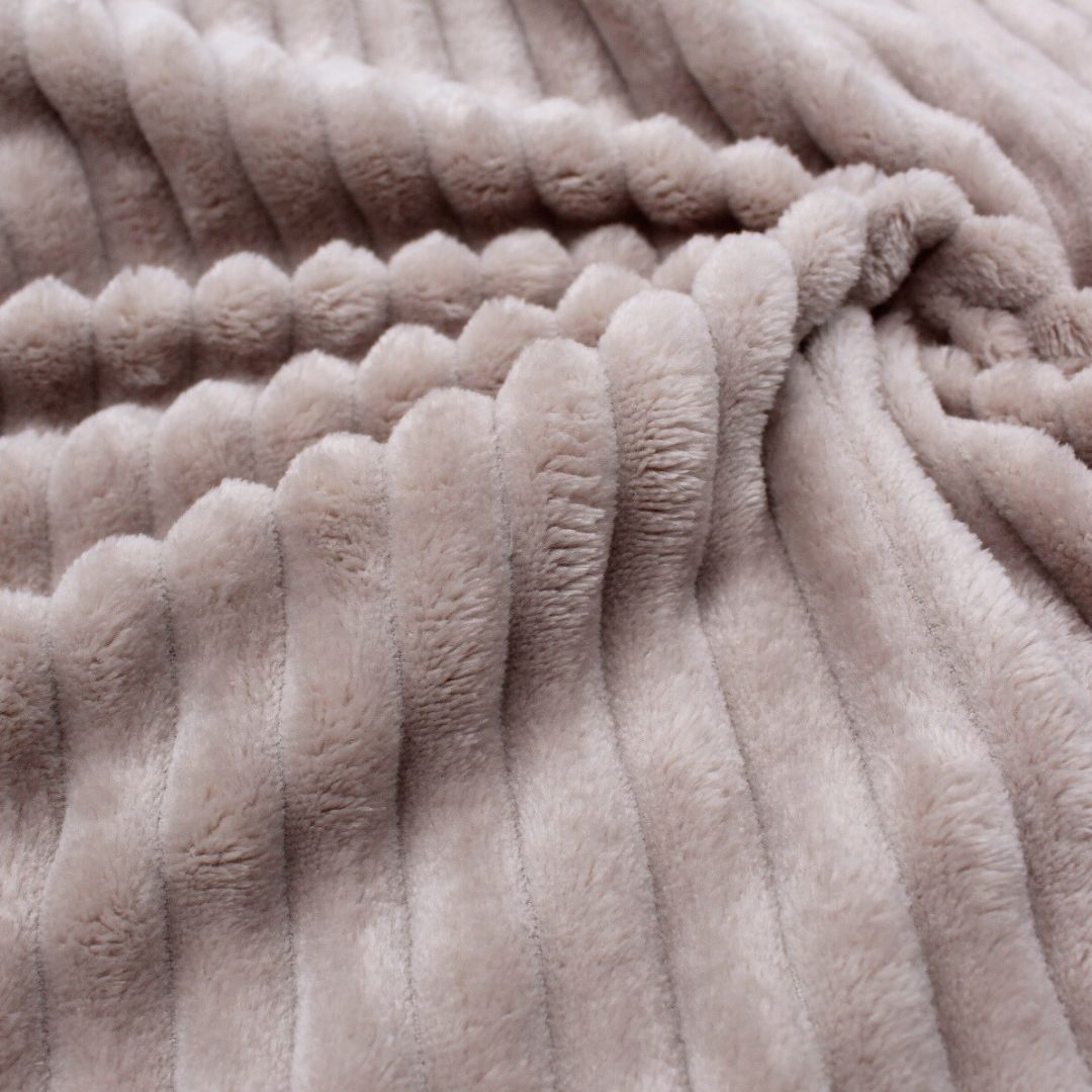 Detailansicht des weichen gerippten Kuschelfleece-Stoffs in Sand – ideal für gemütliche Decken und Kissen.