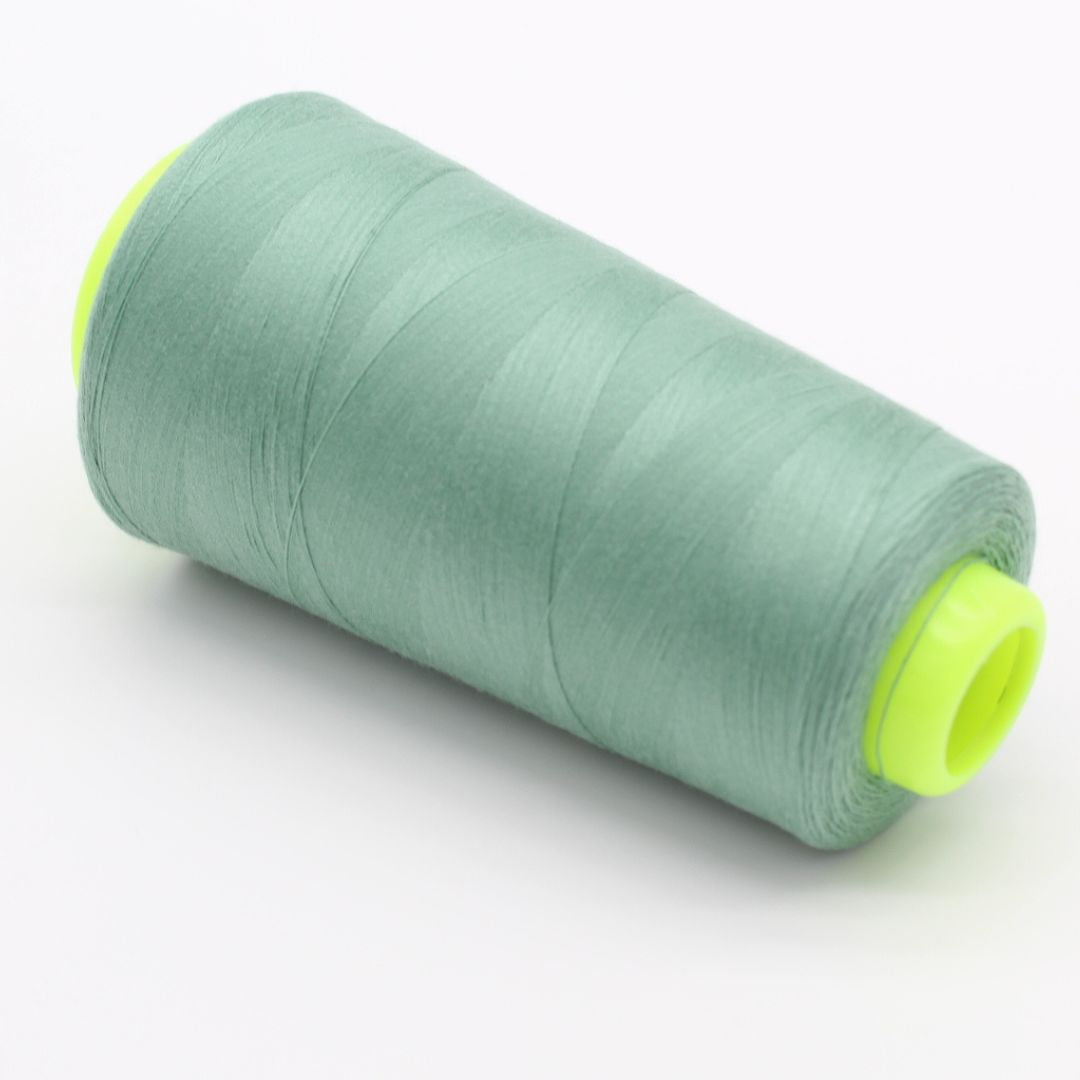 Nahaufnahme einer Rolle Overlockgarn in Staubgrün, 2700 Meter lang, ideal für Overlock-Nähmaschinen.