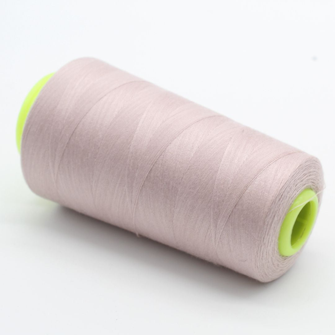 Nahaufnahme einer Rolle Overlockgarn in Puderrosa, 2700 Meter lang, ideal für Overlock-Nähmaschinen.