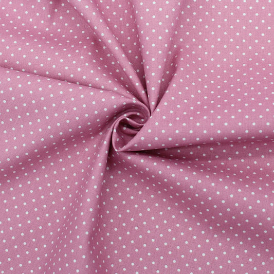 Popeline mit kleinen weißen Tupfen auf Rosa, ideal für die Herstellung von Sommerkleidern, Röcken und Kissenbezügen. Nahaufnahme
