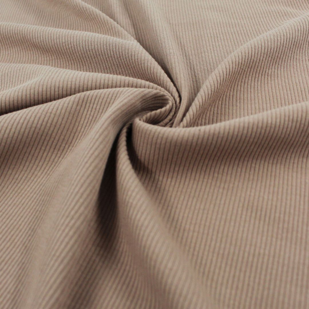 Ribjersey Taupe auf einem Tisch – Weicher und elastischer Ribjersey in Karamellbraun, ideal für Baby- und Kinderkleidung.