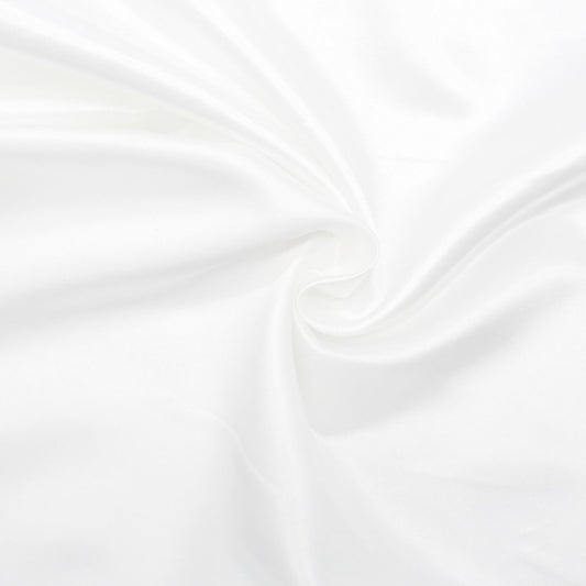 Nahaufnahme des glänzenden Satin-Stoffs in Ecru, ideal für Ballkleider und Dekorationen.