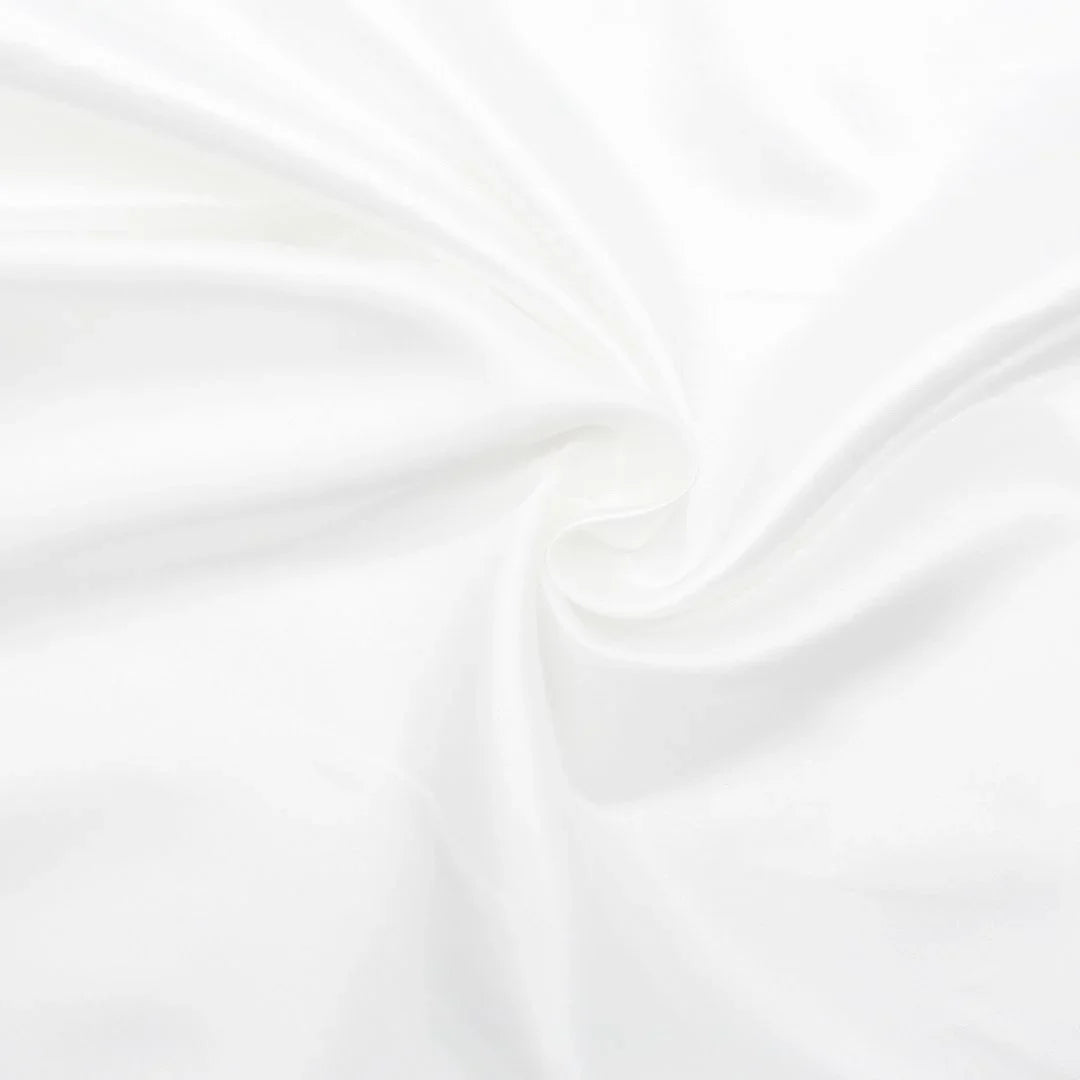Nahaufnahme des glänzenden Satin-Stoffs in Ecru, ideal für Ballkleider und Dekorationen.