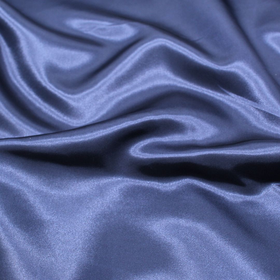 Nahaufnahme des glänzenden Satin-Stoffs in Marineblau, ideal für Ballkleider und Dekorationen.