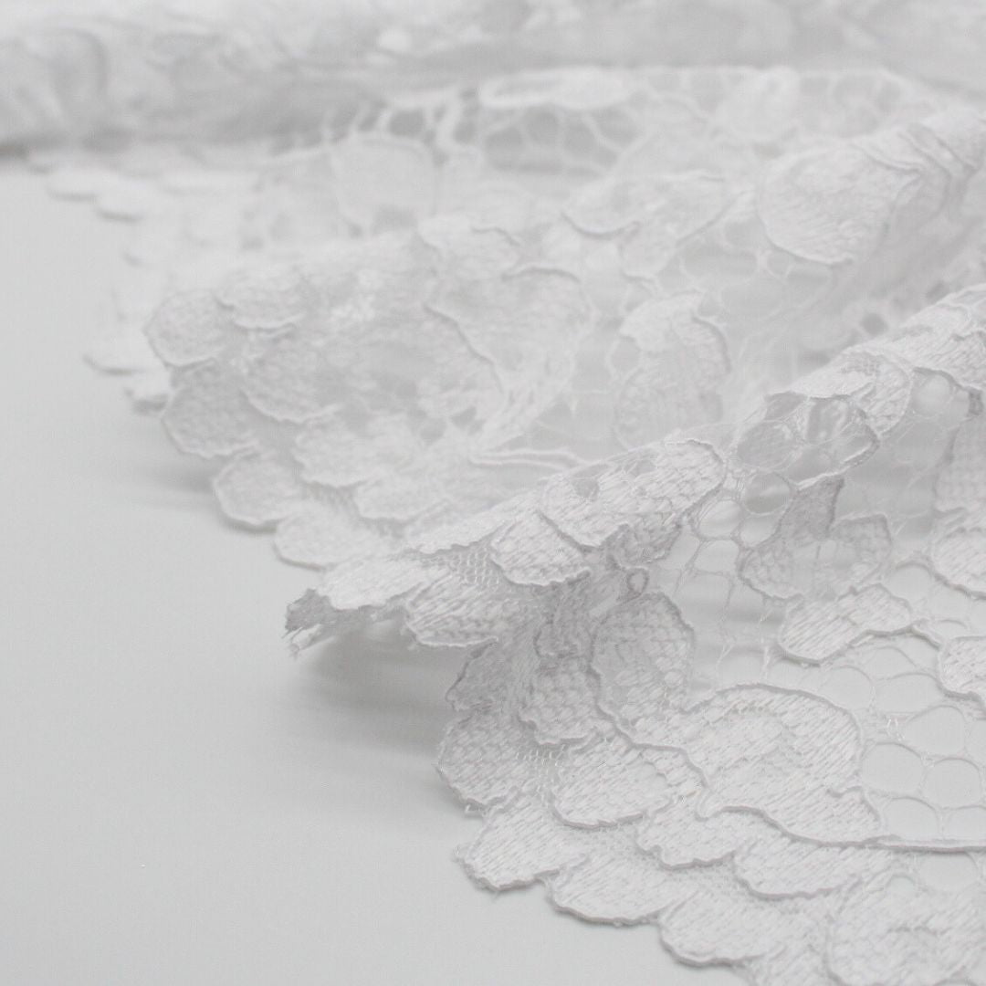 Eleganter schwarzer Spitzenstoff, drapiert und mit aufwendigem floralen Muster für Abendmode. Spitzenrand