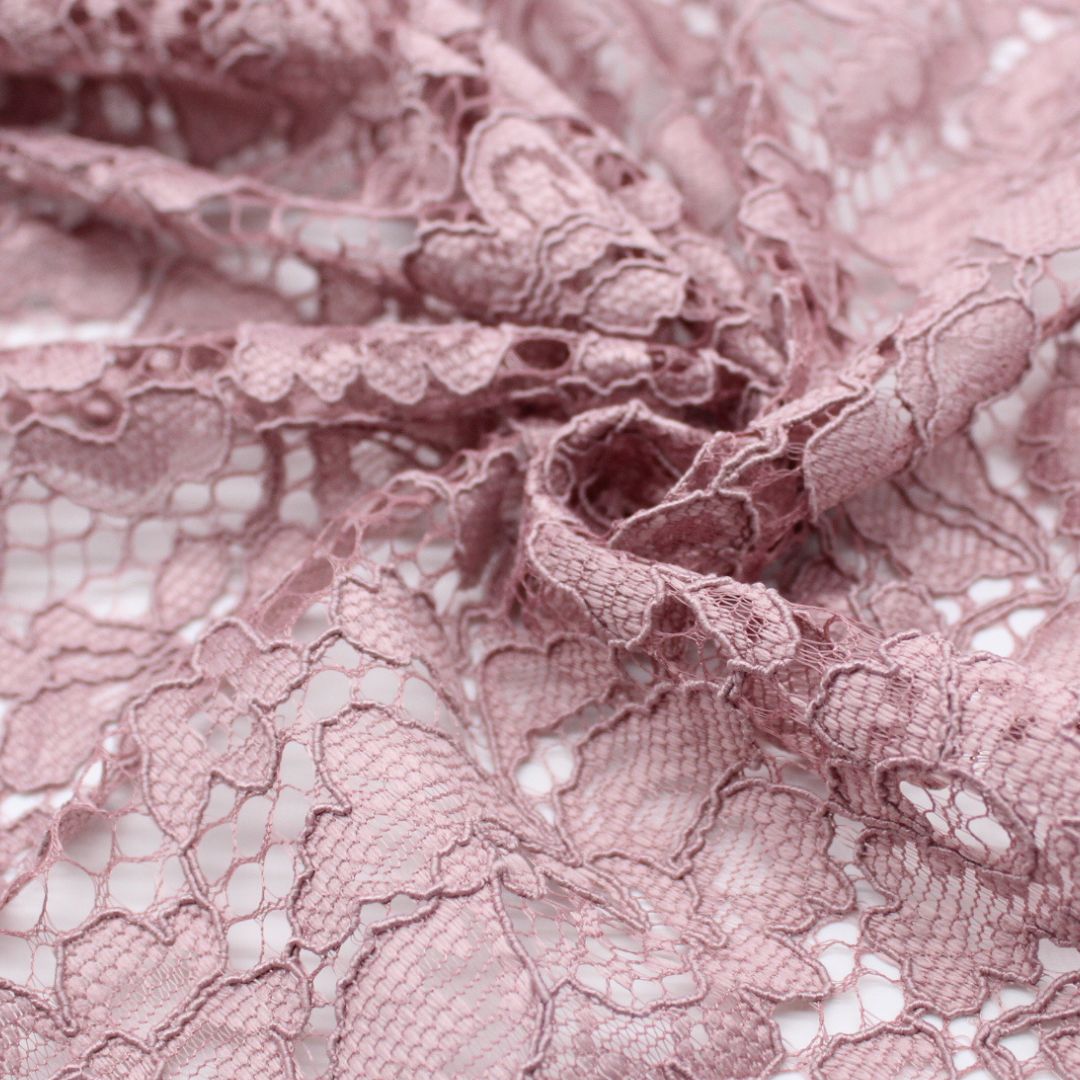 Nahaufnahme eines eleganten Spitzenstoffs mit filigranem Spitzensaum an beiden Seiten in Altrosa