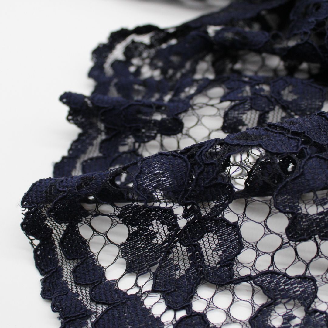 Nahaufnahme eines eleganten Spitzenstoffs mit filigranem Spitzensaum an beiden Seiten in Marineblau