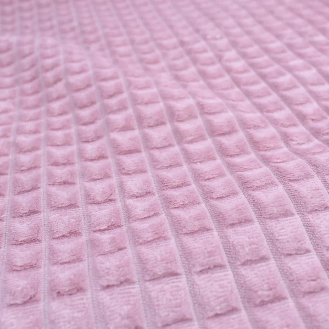 Dekostoff mit strukturierter Oberfläche und Quadrat-Prägung in Rosa