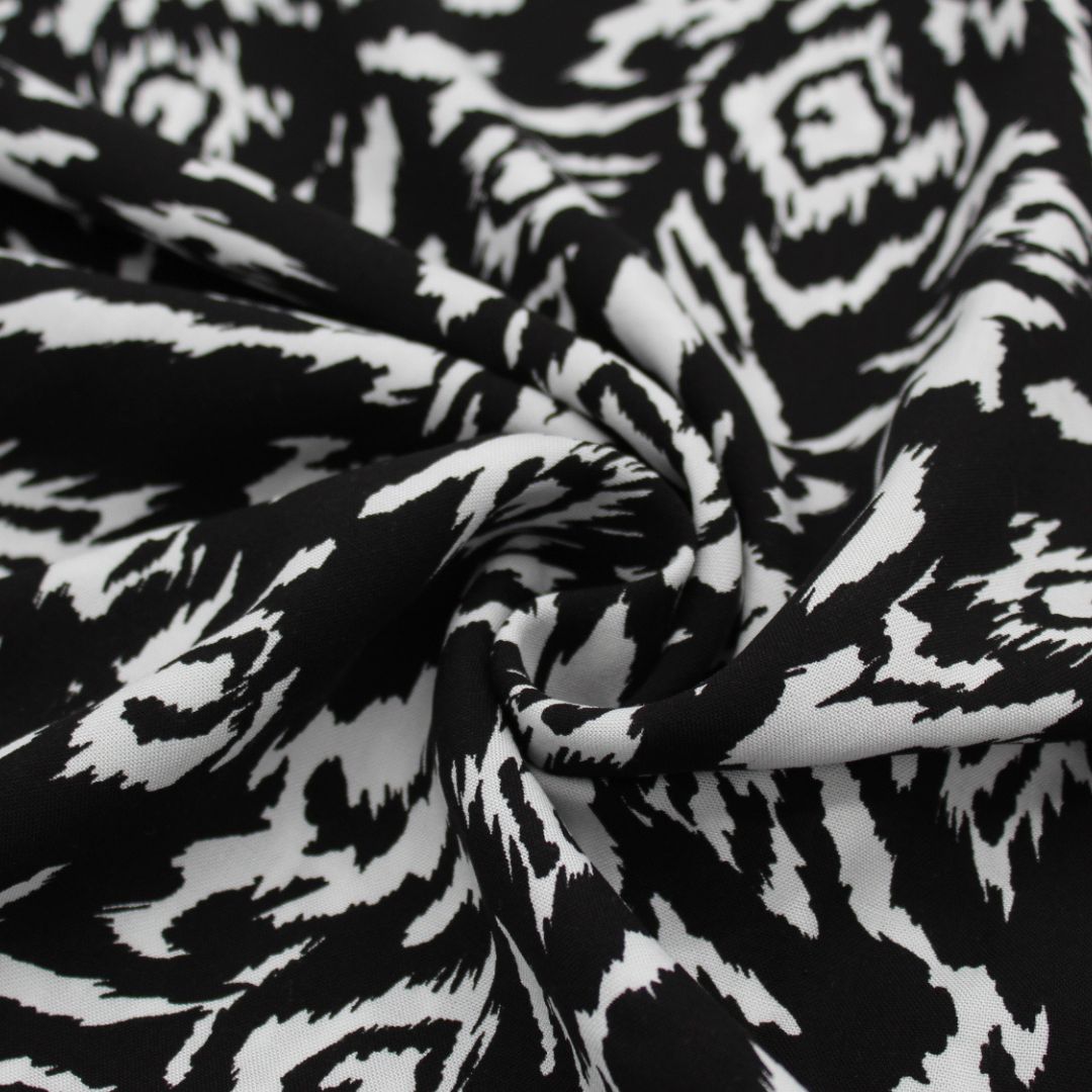 Viskosestoff in Schwarz und Weiß mit abstraktem Design, ideal für die Herstellung von Kleidern und Blusen. Nahaufnahme