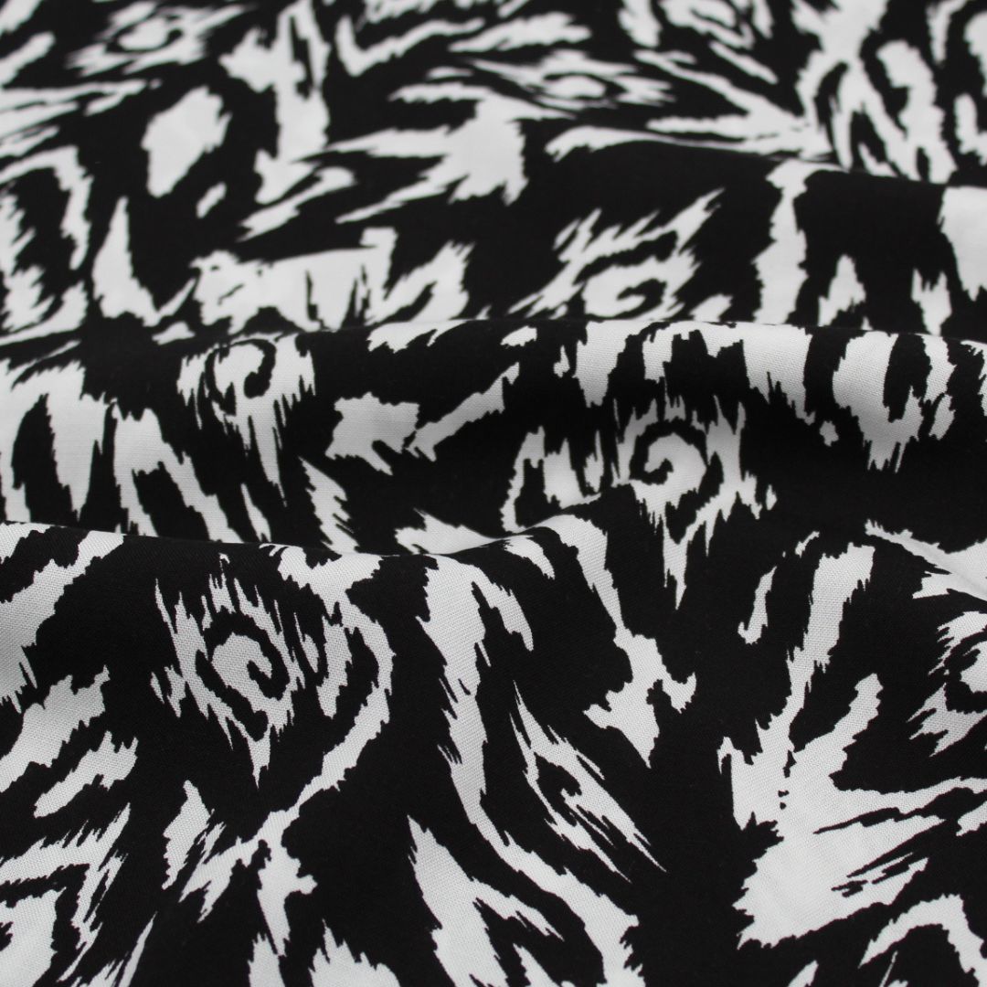 Viskosestoff in Schwarz und Weiß mit abstraktem Design, ideal für die Herstellung von Kleidern und Blusen.