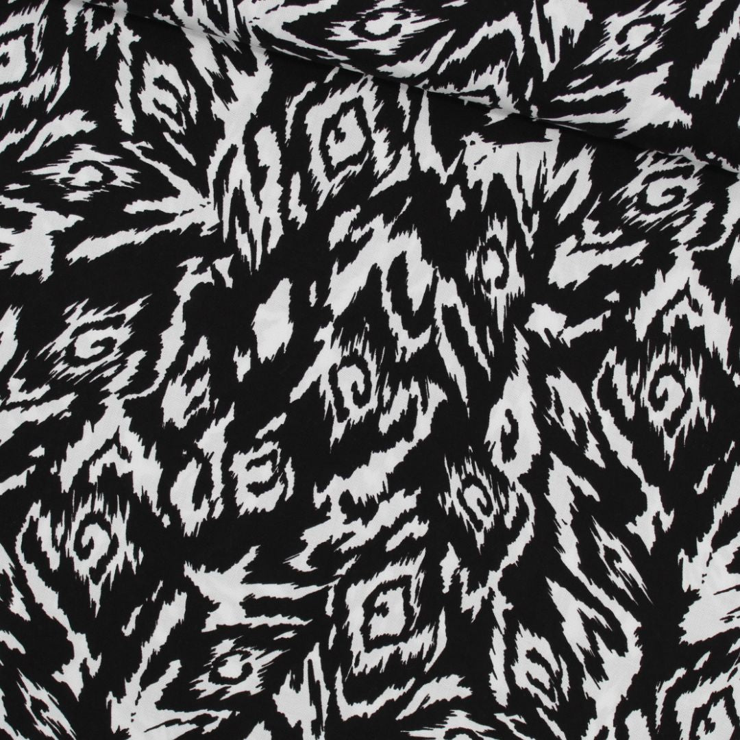 Viskosestoff in Schwarz und Weiß mit abstraktem Design, ideal für die Herstellung von Kleidern und Blusen. Stoffball