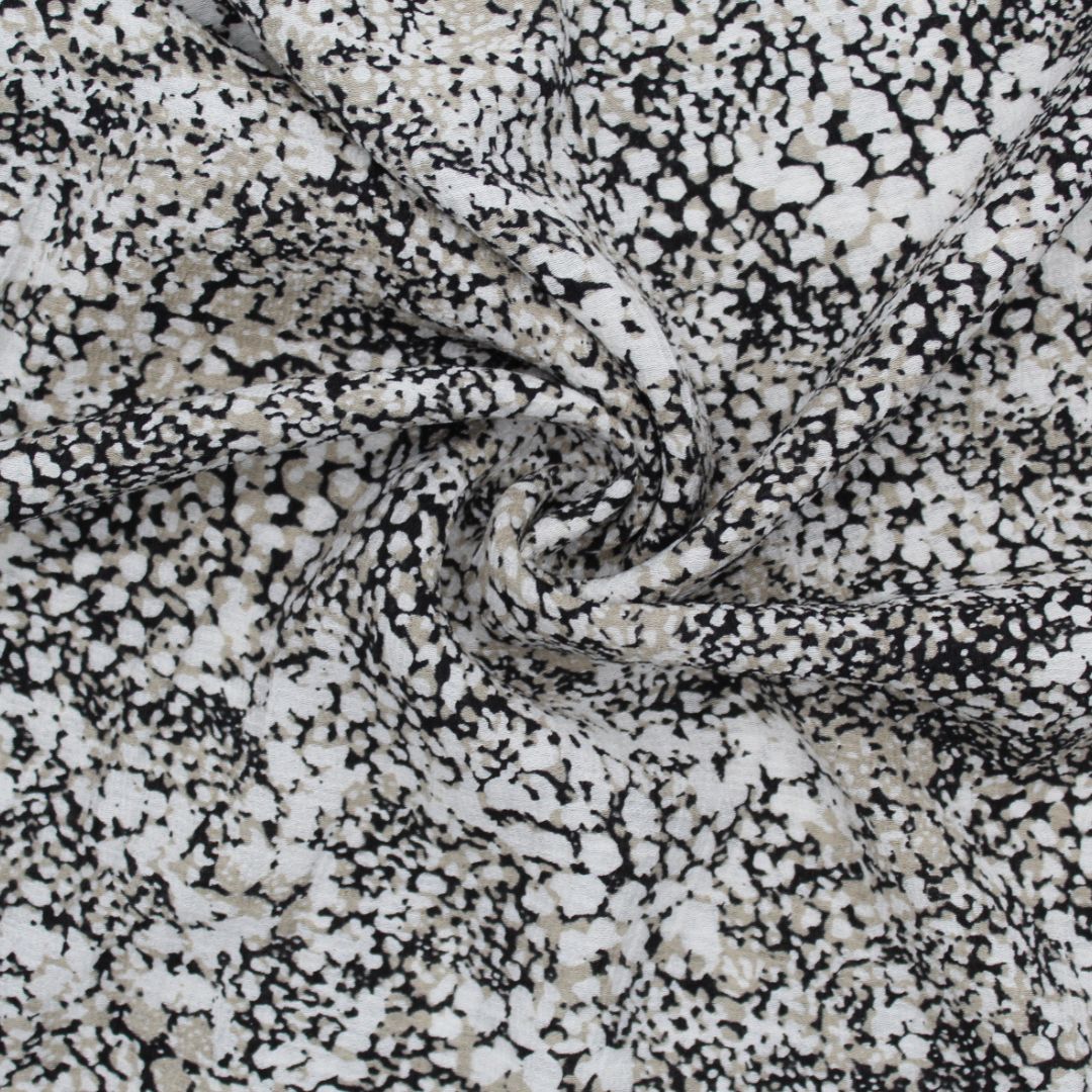 Viskosestoff Crincle mit abstrakten Punkten in Sand, Schwarz und Cremeweiß, ideal für die Herstellung von Kleidern und Blusen.