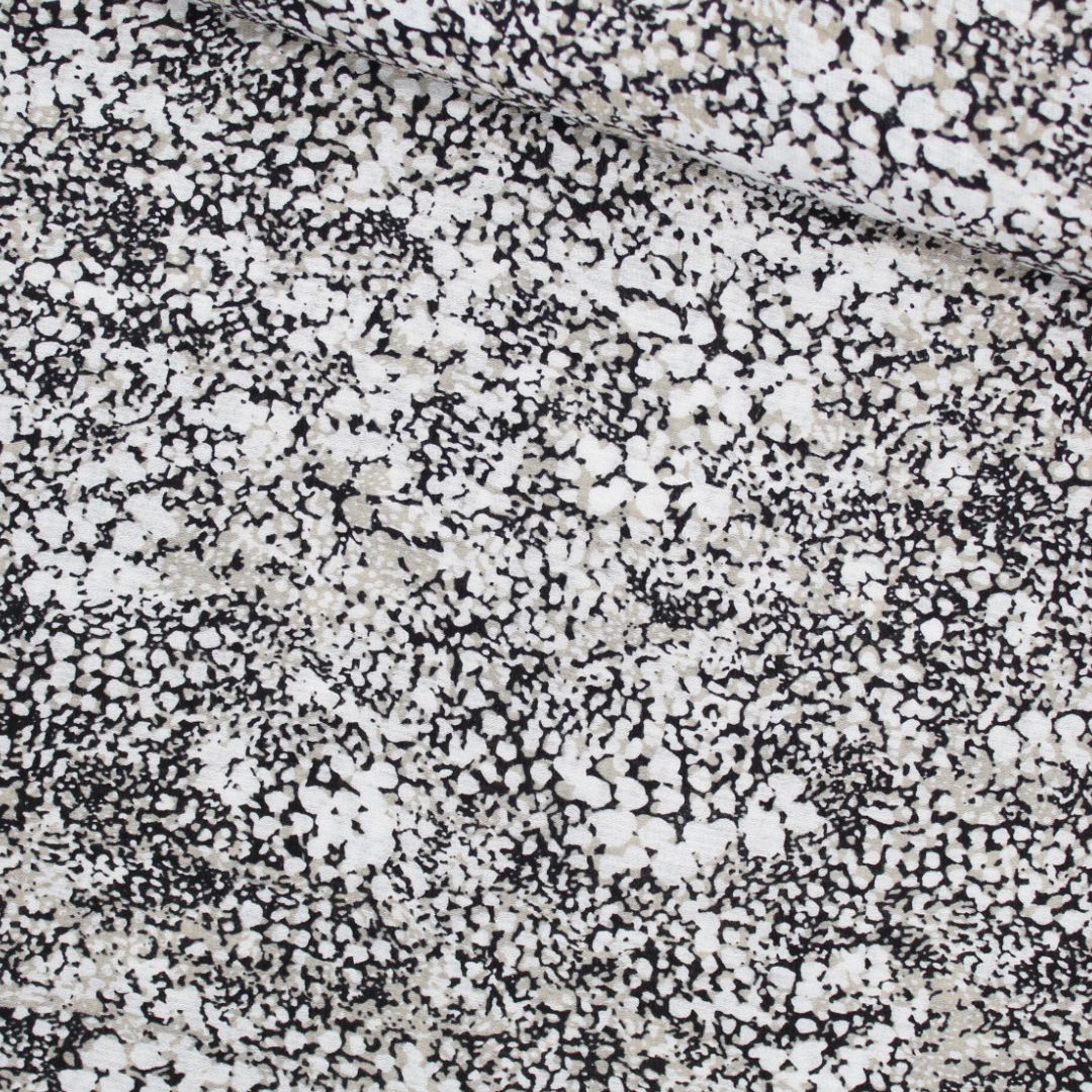 Viskosestoff Crincle mit abstrakten Punkten in Sand, Schwarz und Cremeweiß, ideal für die Herstellung von Kleidern und Blusen. Stoffball