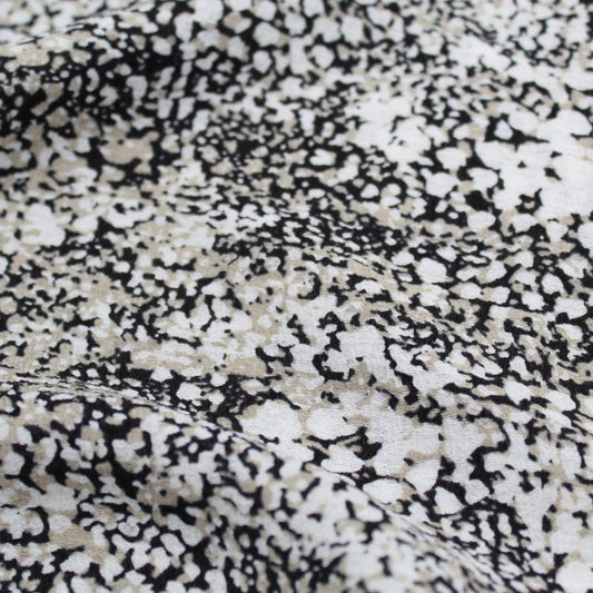 Viskosestoff Crincle mit abstrakten Punkten in Sand, Schwarz und Cremeweiß, ideal für die Herstellung von Kleidern und Blusen.