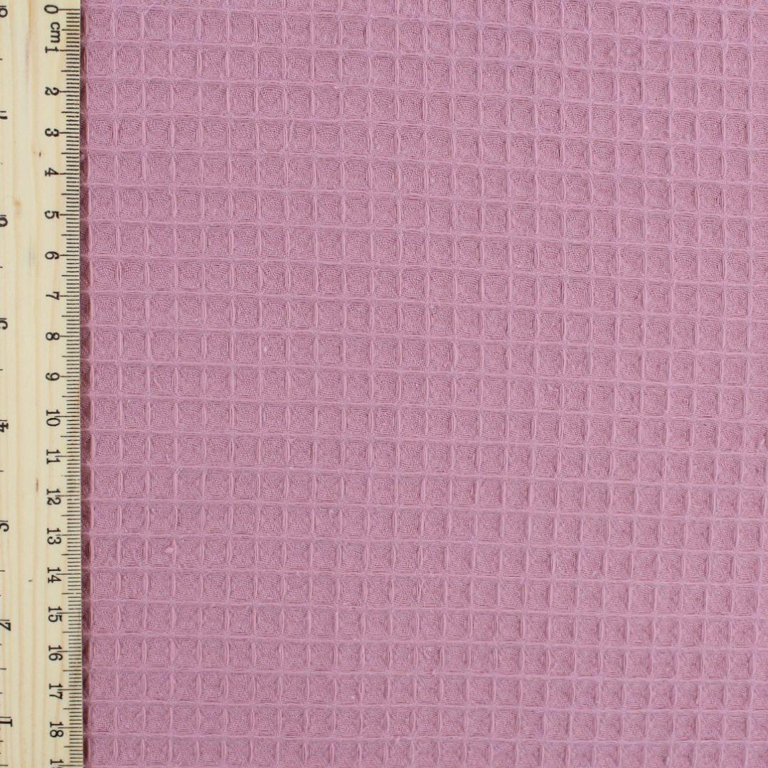 Fein gewebter Waffelstoff in zartem Rosa -Ton, ideal für Heimtextilien und Bekleidung.