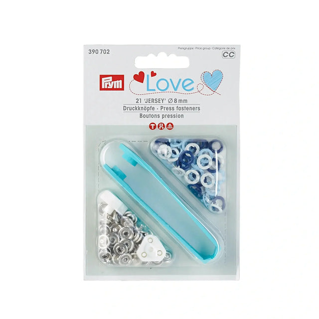 Nähfrei-Druckknöpfe „Jersey“ in Verpackung: Eine Packung mit 21 blau, hellblauen und weißen Nähfrei-Druckknöpfen der Größe 8 mm. Die Verpackung zeigt die sortierte Farbvarianz der Knöpfe.