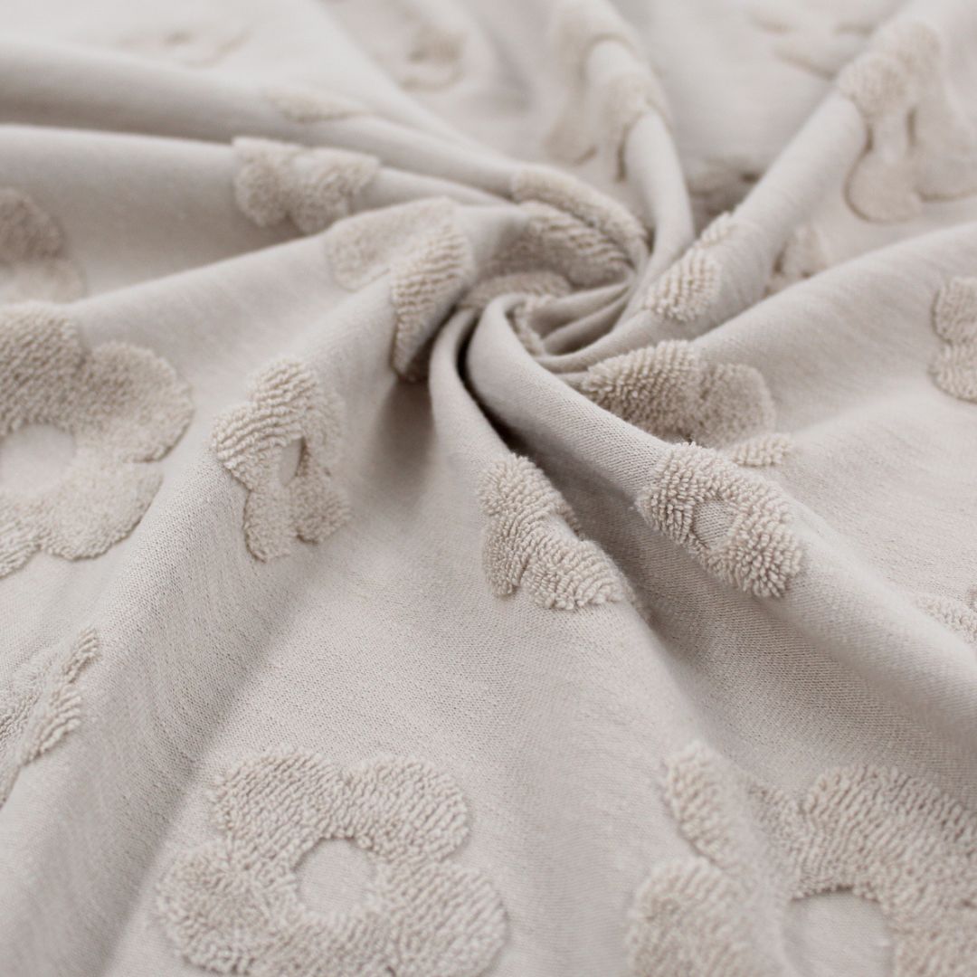 Detailansicht: Sandfarbener Jacquard-Stoff mit floralen Frottee-Mustern und feiner Textur