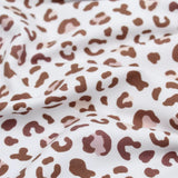 Weicher Jersey-Stoff mit stilvollem Leopardenmuster in Braun auf Weiß – ideal für Kleidung und Accessoires.