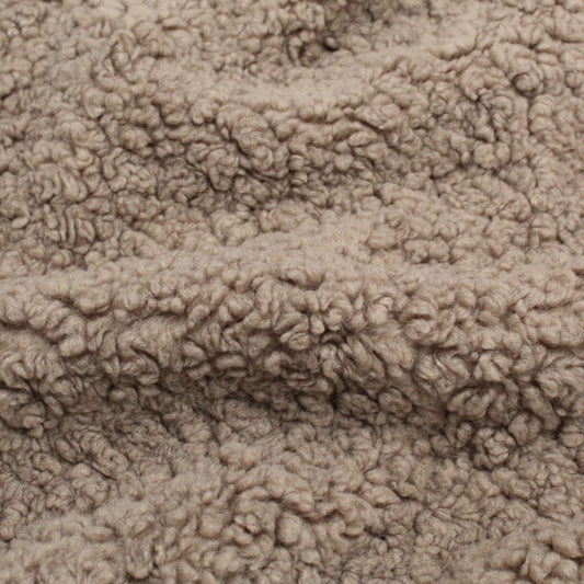 Kuscheliger Boucle Stoff in Taupe, der auf einem Tisch ausgebreitet ist, um die weiche Textur zu zeigen.