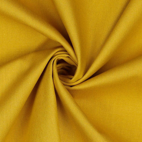 Hochwertige Baumwollpopeline in Ockergelb – eleganter Stoff auf einem Schneiderpuppe drapiert.