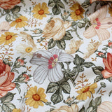 Retro floral cotton fabric with yellow, beige, and orange flowers on a white background