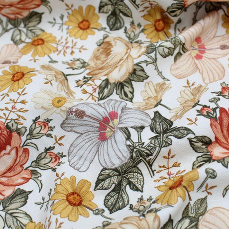 Retro floral cotton fabric with yellow, beige, and orange flowers on a white background