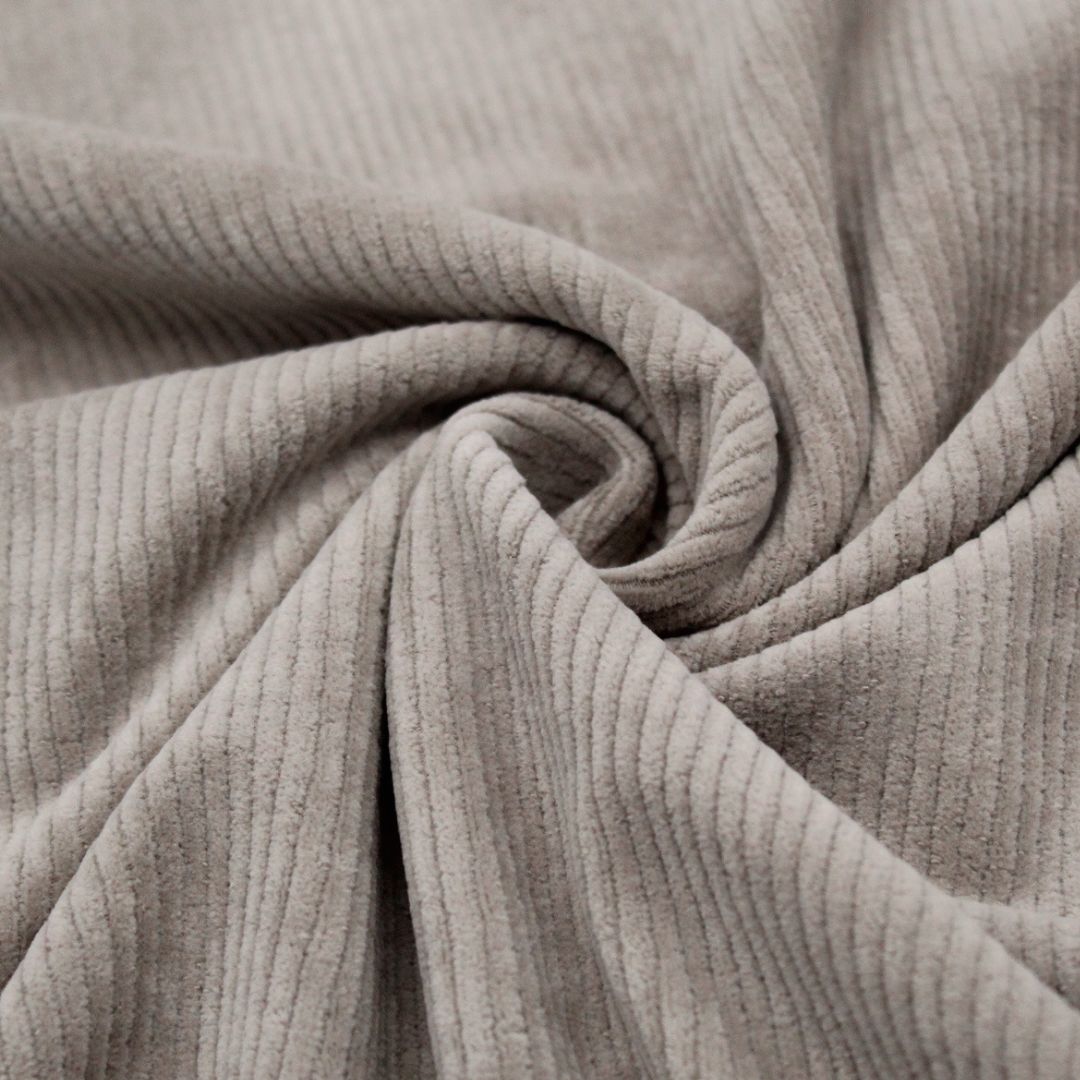 Detailaufnahme der breiten Rippenstruktur des Cord Jerseys in Taupe, weich und elastisch für maximalen Komfort.