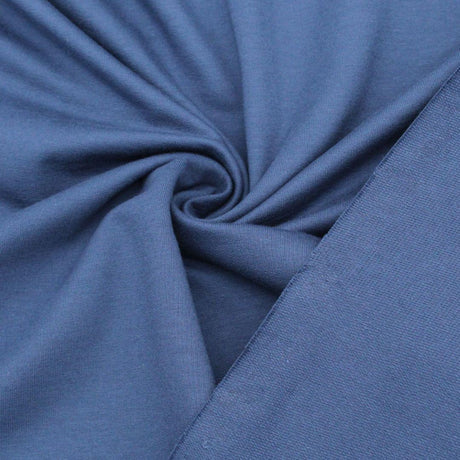 Nahaufnahme des French Terry Sweatstoffs in Jeansblau mit glatter Außenseite und typischer Schlingenstruktur auf der Innenseite.