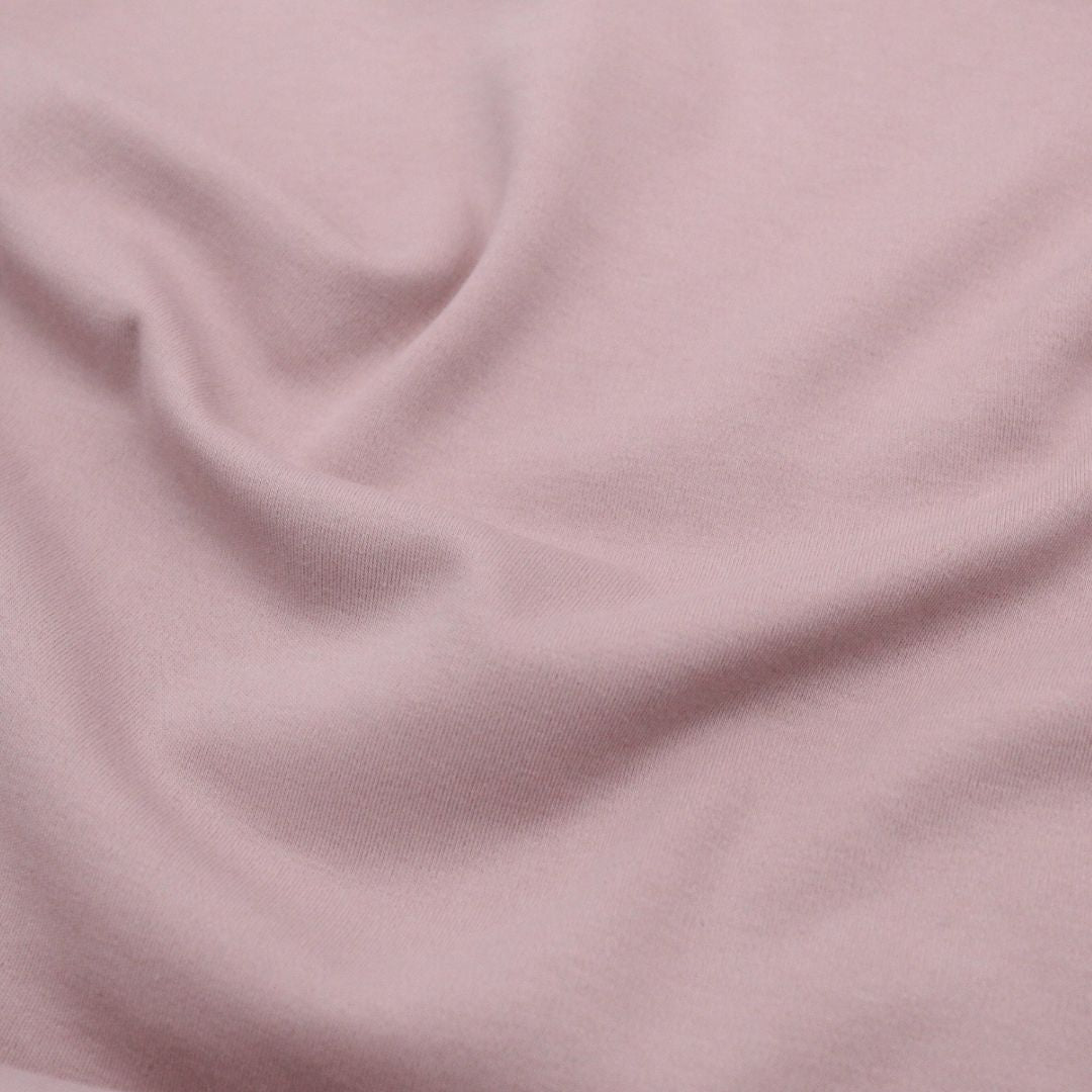 Nahaufnahme des doppelseitigen Interlock Jersey, der die luxuriöse Textur und Weichheit des Stoffes zeigt. Nude Rosa