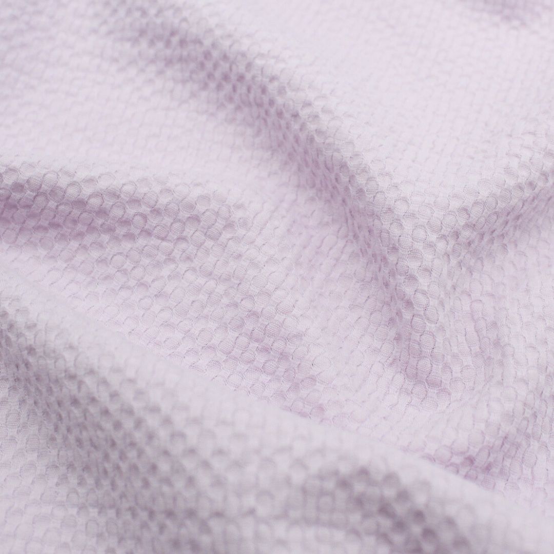 Leichte Baumwolle mit Bienenwaben-Jacquard-Struktur, ideal für die Herstellung von Sommerblusen, Tops und Kleidern – strapazierfähig und pflegeleicht. Pastell Lila