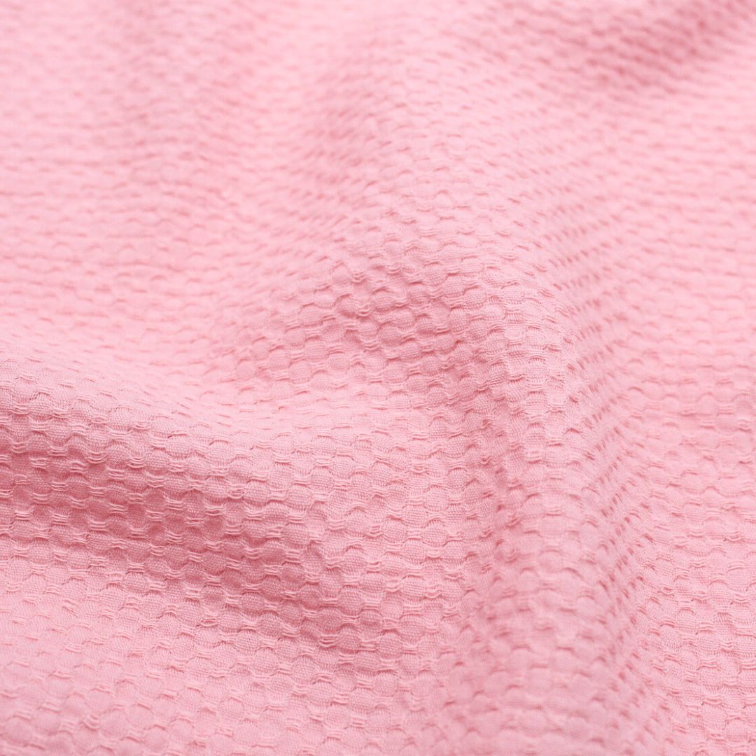 Leichte Baumwolle mit Bienenwaben-Jacquard-Struktur, ideal für die Herstellung von Sommerblusen, Tops und Kleidern – strapazierfähig und pflegeleicht. Rosa