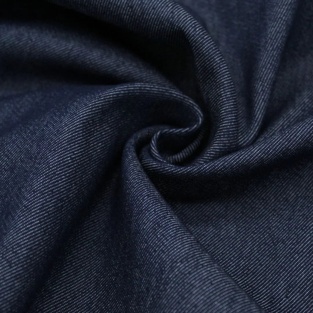 Nahaufnahme von robustem Jeansstoff, der die raue, körnige Oberfläche und die typische Textur zeigt. Indigo Blau