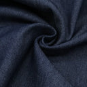 Nahaufnahme von robustem Jeansstoff, der die raue, körnige Oberfläche und die typische Textur zeigt. Indigo Blau