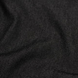 Nahaufnahme von schwarzem Jeansstoff mit diagonaler Textur, die seine Robustheit betont