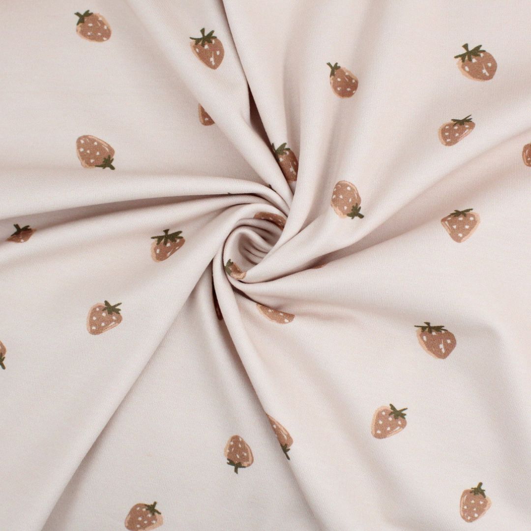 Detailansicht Jersey mit Erdbeeren auf sandfarbenem Hintergrund – feines Muster in Nahaufnahme