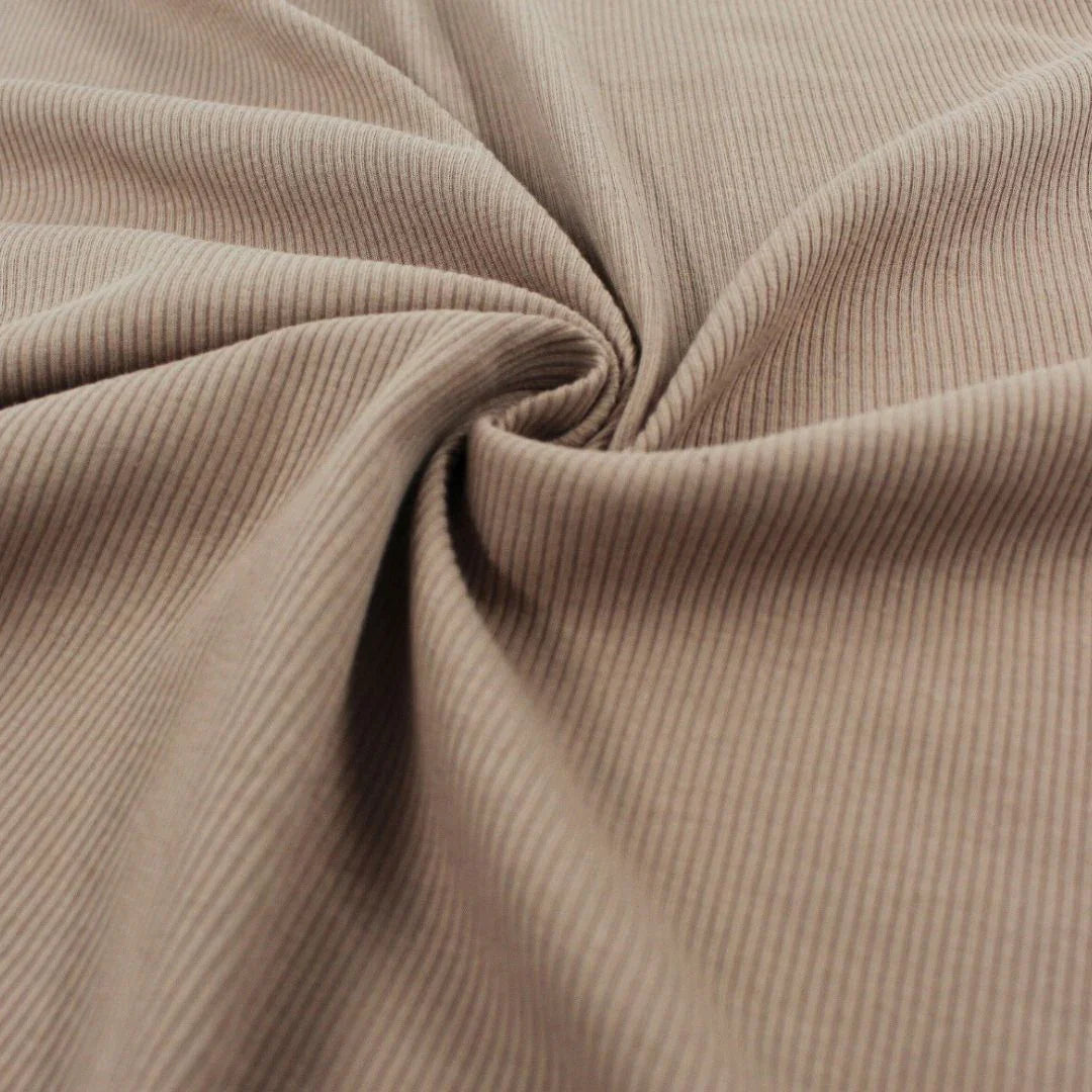 Ribjersey Taupe auf einem Tisch – Weicher und elastischer Ribjersey in Karamellbraun, ideal für Baby- und Kinderkleidung.